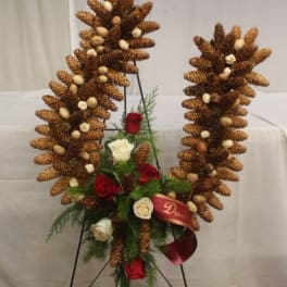 Pinecone wreath with red and white roses on a stand