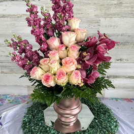 Pink roses and purple orchids in a rose-gold vase