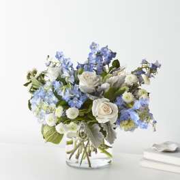 Blue and white flower arrangement in a clear glass vase