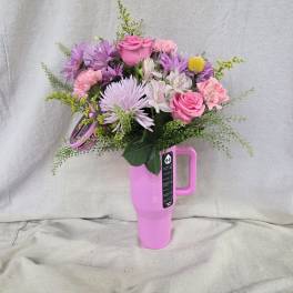 Pink and purple mixed bouquet arranged in a bright pink handled travel tumbler