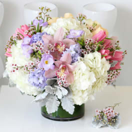Mixed pastel bouquet in a glass vase with a matching boutonniere