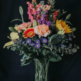 Mixed bouquet of colorful flowers in a clear glass vase