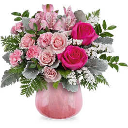 Pink rose bouquet in a pink glass vase with silver foliage
