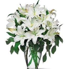 White lilies arranged in a clear glass vase