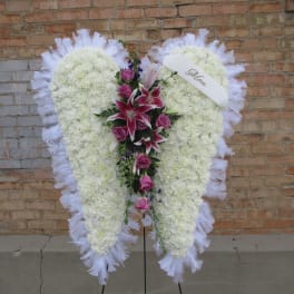 Heart-shaped white floral standing spray with pink lilies and roses