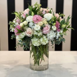 Pink and white roses arranged in a clear glass vase