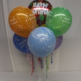 Cluster of colorful birthday balloons on a clear stand