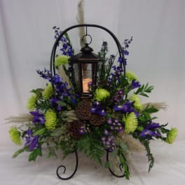 Lantern centerpiece surrounded by purple and green flowers