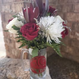 Bouquet of red and white roses with white chrysanthemum in a glass mug