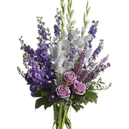 Purple and white floral arrangement in a clear glass vase