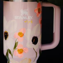 Pink Stanley tumbler with painted flowers and a handle