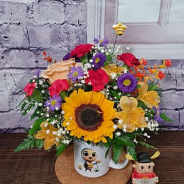 Sunflower bouquet in a mug with a small bee figurine