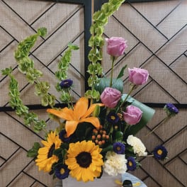Mixed bouquet with sunflowers, pink roses, and orange lilies in a white box