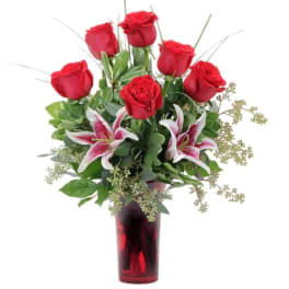 Red roses and pink lilies in a red glass vase