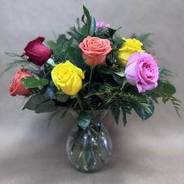 Bouquet of multicolored roses in a clear glass vase