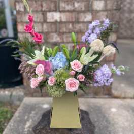 Mixed bouquet in a tall vase with pink, lavender, and white flowers