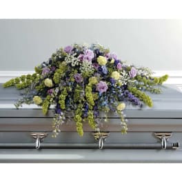 Lavender and white floral spray on a gray casket