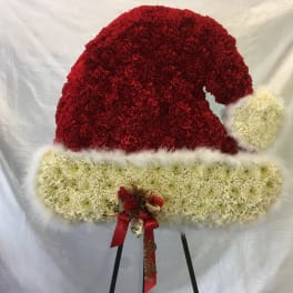 Red and white floral Santa hat on an easel
