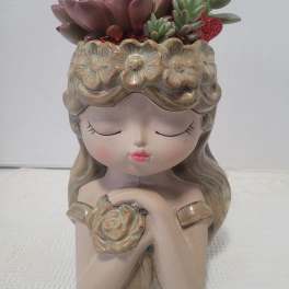 Ceramic girl planter with succulent arrangement on top
