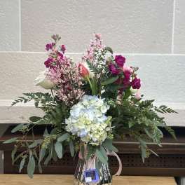 Mixed bouquet in a metallic vase with pink, white, and blue blooms