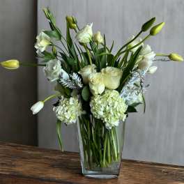 White roses and hydrangeas in a clear glass vase