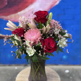 Bouquet of red roses and pink flowers in a glass vase