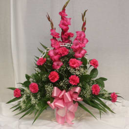Tall pink floral arrangement with a ribbon bow in a basket