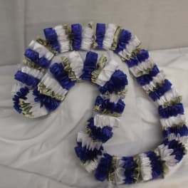 Blue, white, and money lei garlands arranged on a bed