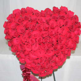 Heart-shaped bouquet of red roses with a ribbon at the base