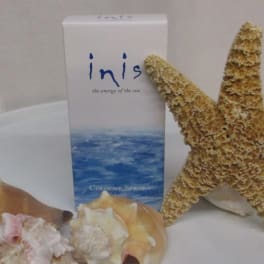 Seashells and a starfish arranged beside a cologne spray box