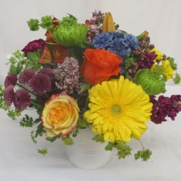 Mixed bouquet of colorful flowers in a white vase