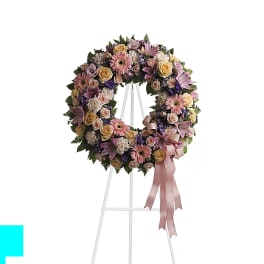 Pastel floral wreath on a white easel with a pink ribbon
