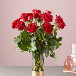 Red roses arranged in a clear glass vase