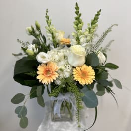 Bouquet of white and peach flowers in a glass vase