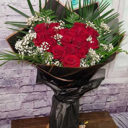 Bouquet of red roses with white baby's breath in black wrap
