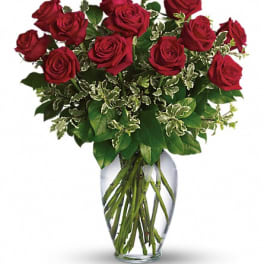 Red roses arranged in a clear glass vase