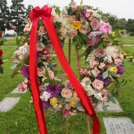 Floral wreath on a wooden easel with a red ribbon bow
