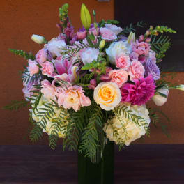 Mixed pink and white flower bouquet in a tall glass vase