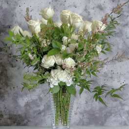 White roses and hydrangea in a clear glass vase