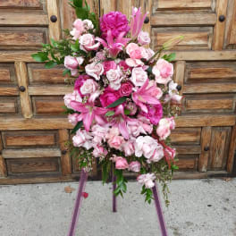 Pink and white floral standing arrangement on a purple easel