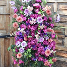 Tall floral spray with purple, pink, and peach blooms