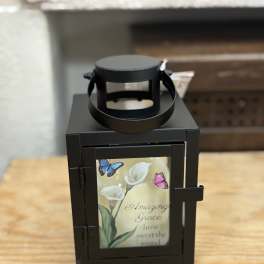 Black lantern with a floral memorial-style insert and butterflies