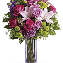 Bouquet of pink and purple flowers in a tall glass vase