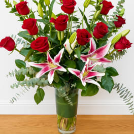 Red roses and pink lilies in a clear glass vase