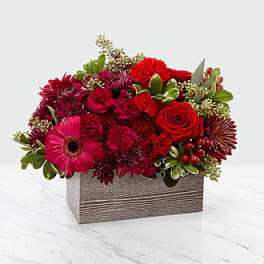 Red and pink mixed flower arrangement in a rectangular wooden box