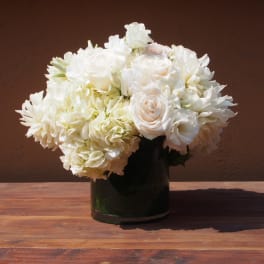 White floral arrangement in a dark glass vase