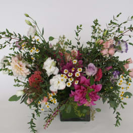 Mixed floral arrangement in a black vase with pink, white, and purple blooms
