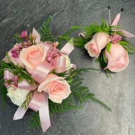 Pink rose corsage and boutonniere with ribbon and greenery