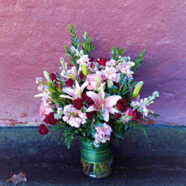 Bouquet of pink lilies and red roses in a glass vase
