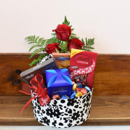 Red roses with assorted chocolates in a patterned gift box